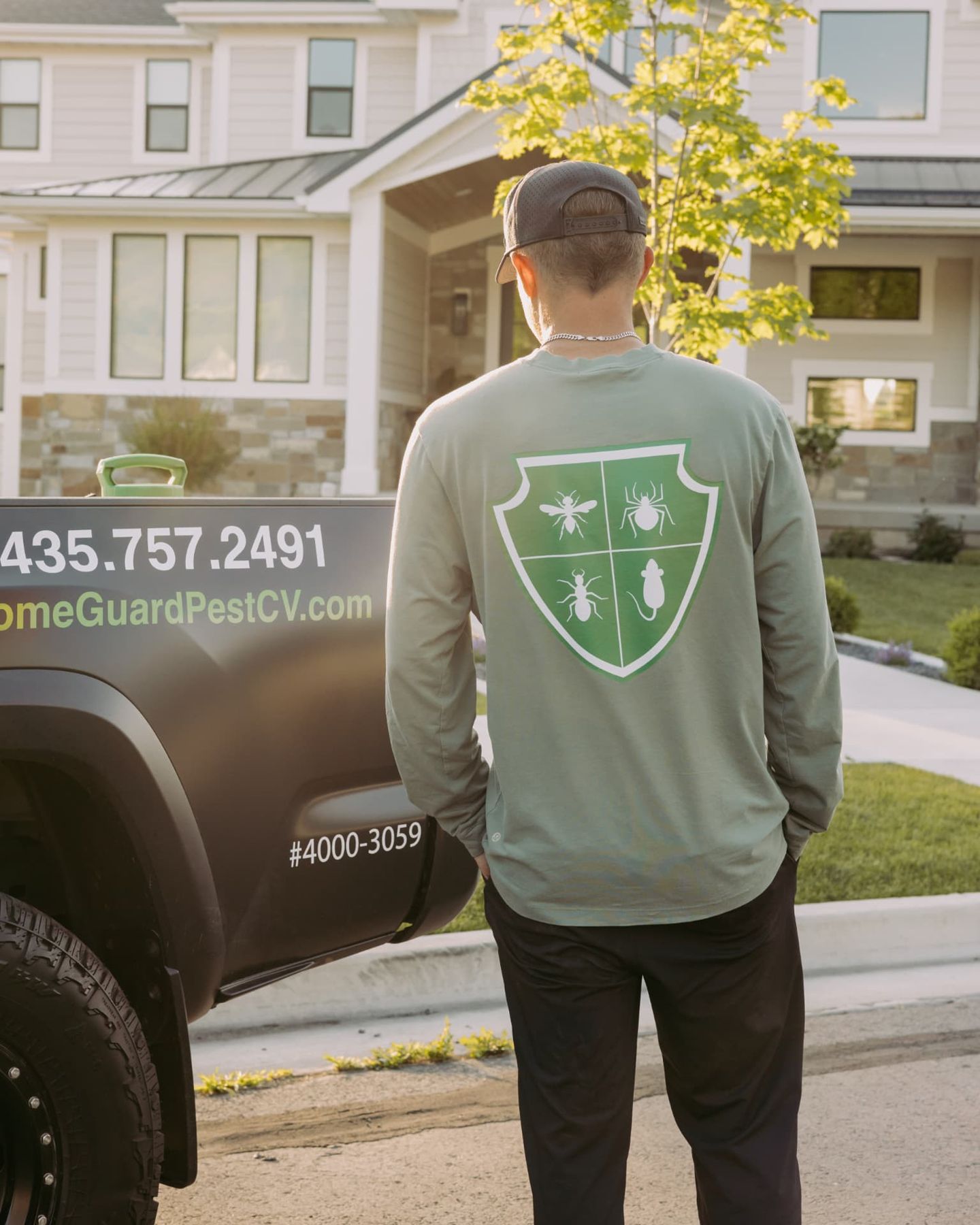 HomeGuard technician in a branded shirt outside a Cache Valley home